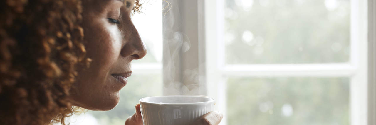 How I'm Mourning the Loss of Estranged Parents Black woman smelling coffee with eyes closed