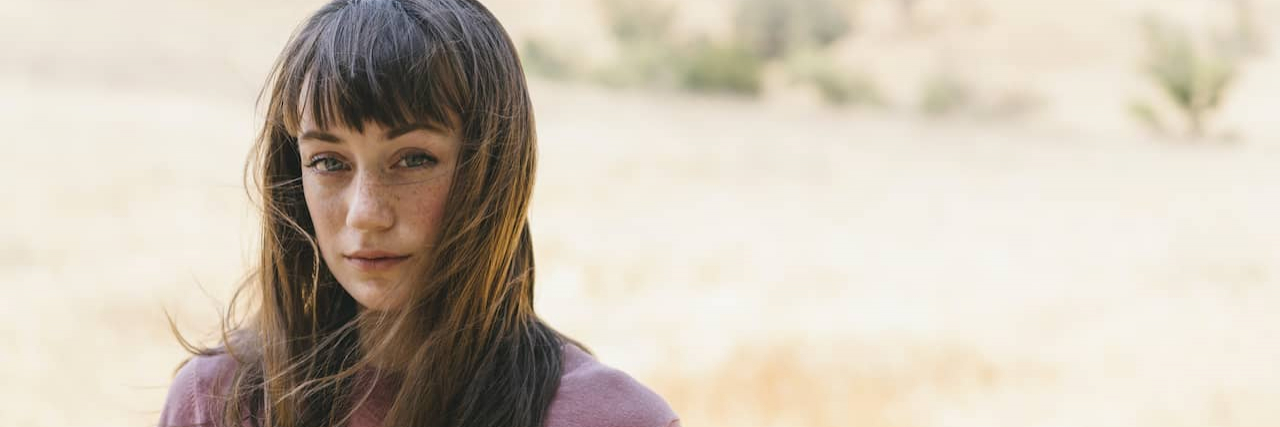 Tips for People New to Disability Advocacy From Long-Haul COVID Woman standing outside with wind in her hair