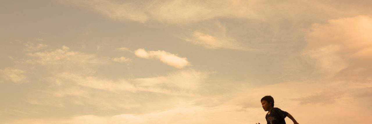 The Strength of My Son With Rare Skin Disease Silhouette of boy running on hill, side view