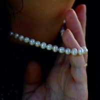 Close-Up Of Woman Holding Pearl Necklace