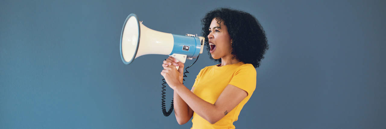 The Importance of Finding Your Voice With Chronic Illness Woman of color speaking into a megaphone