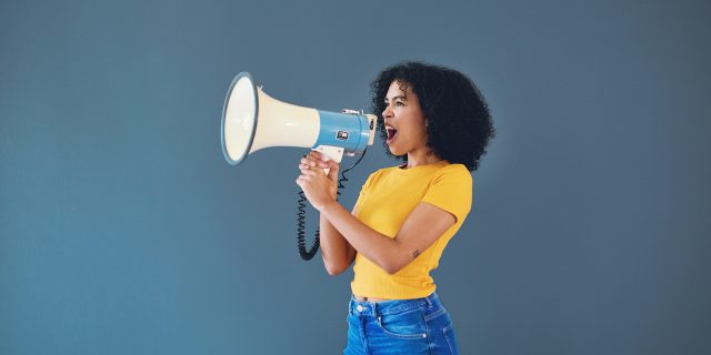 Woman of color speaking into a megaphone