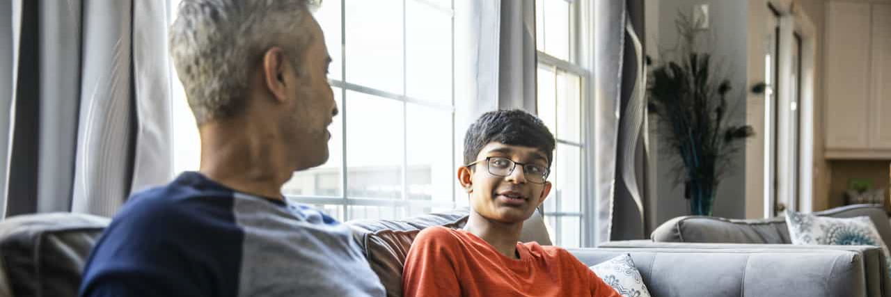 How to Talk to Your Child About Sex Father and son talking on couch at home
