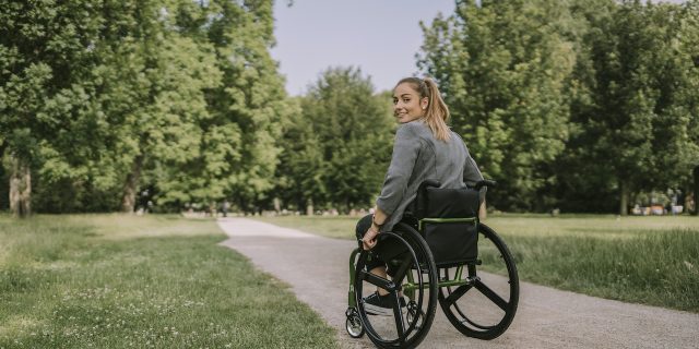 Woman using wheelchair outside on path