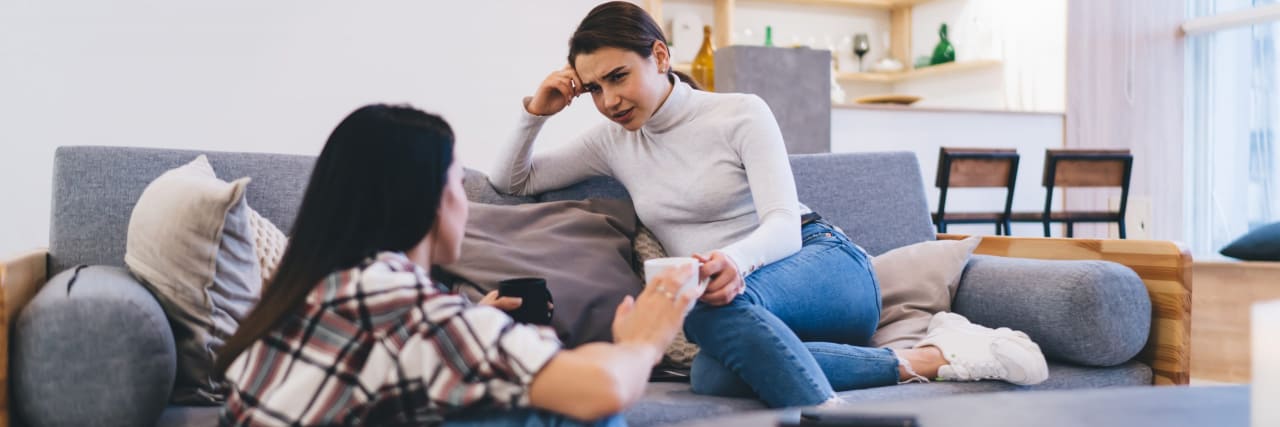 How to Break the Ice When Disclosing IBD to Friends Two women in home wear sitting opposite each other and enjoying conversation while together in living room at daytime