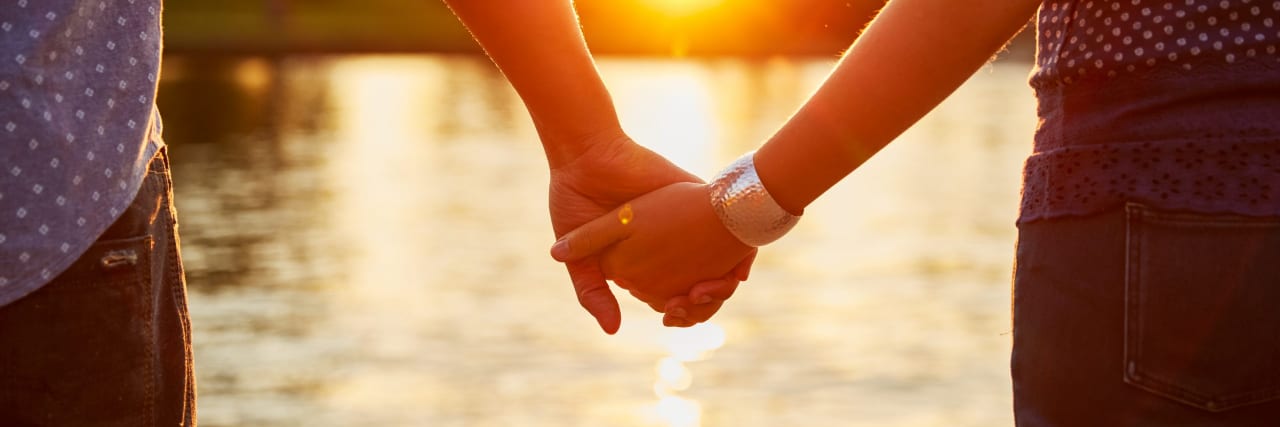 What It's Like Being Married to Someone With UC Couple holding hands next to river.