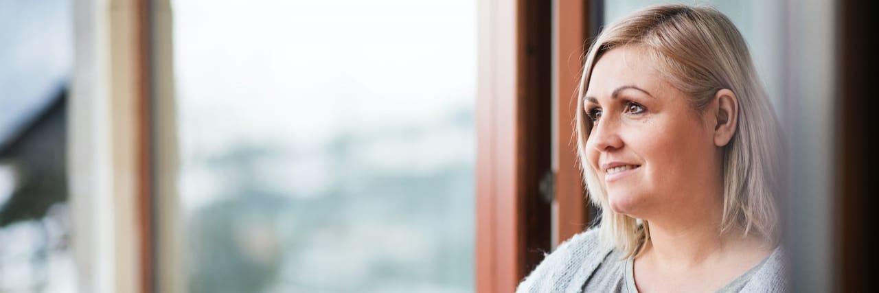 Coping With Activities of Daily Living After Injuring Both Shoulders Woman at home slightly smiling, holding a mug