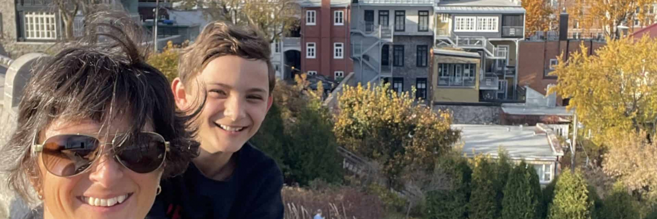 Travel Tips for Brain Injury Survivors Contributor with her son in front of buildings in the Old City in Quebec