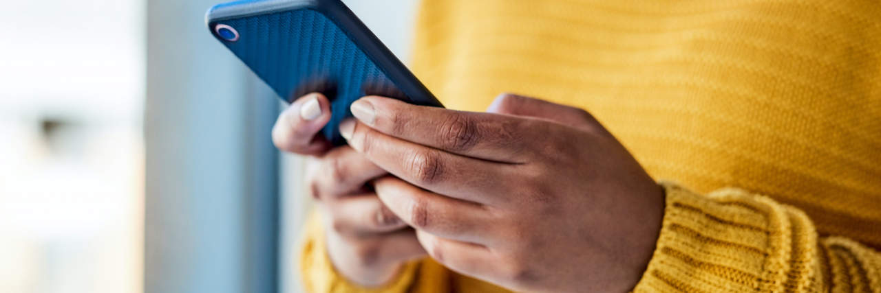 Woman of color holding phone in her hands