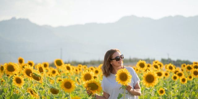 Woman wearing sunglasses in sunflower field