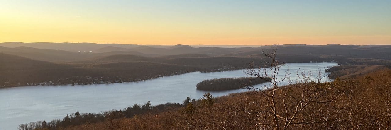 Why Time Spent in Nature Can Be the Key to Unlocking Your Mental Prison Dawn rising over a forest and river seen from atop a small mountain