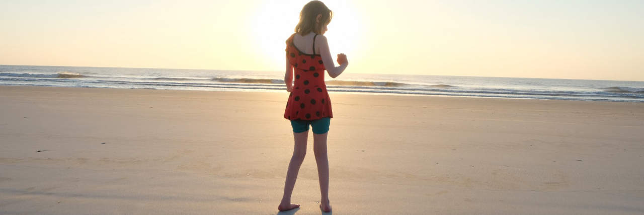 The Decision We Wish We Could Make With Our Daughter Rather Than For Her Silhouette of child standing on beach at sunset