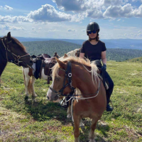 Contributor sitting on a horse with Norwegian mountains in the background