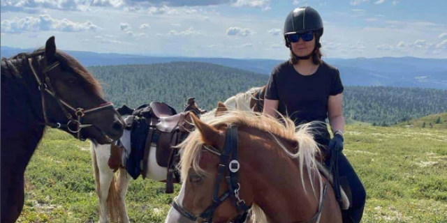 Contributor sitting on a horse with Norwegian mountains in the background