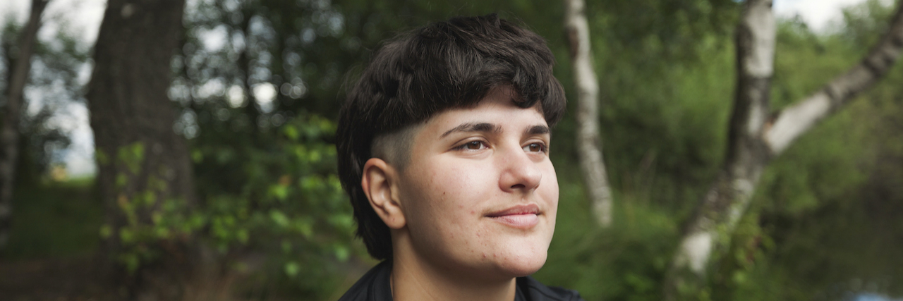 The Significance of Labels Person sitting in nature in front of trees with calm expression