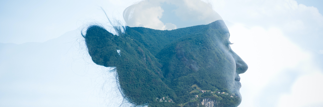 Double exposure of woman with sky and hills