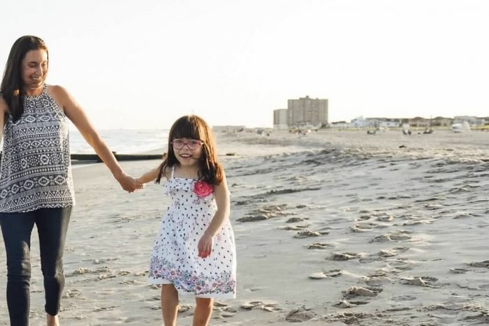 Contributor holding her daughter's hand while walking on the beach