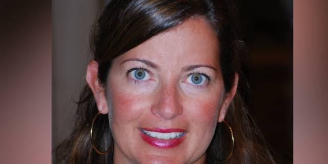 Demystifying Electroconvulsive Therapy Contributor, a woman with long brown hair and blue eyes, smiling and looking forwards