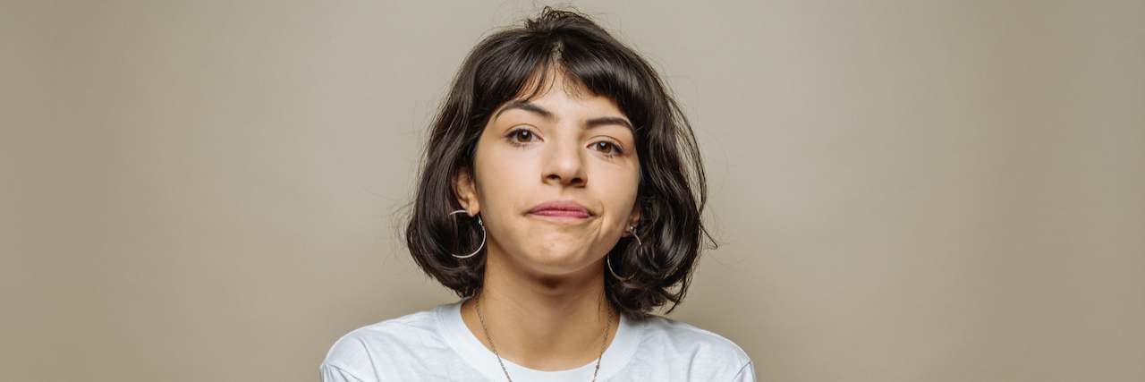 The Role 'Debby Downer' Plays in My Mental Health Young woman looking ahead with lips pursed