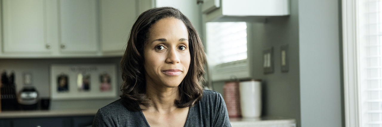 How My Food Allergies Affect Me Socially Portrait of woman of color at kitchen table