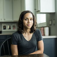 Portrait of woman of color at kitchen table