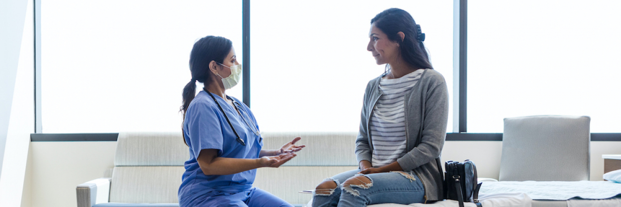 A woman medical practioner speaks with a woman patient