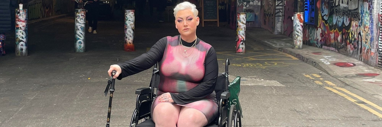 How I Coped When a Diagnosis Devastated My Modeling Career Contributor posing proudly in her wheelchair holding her cane