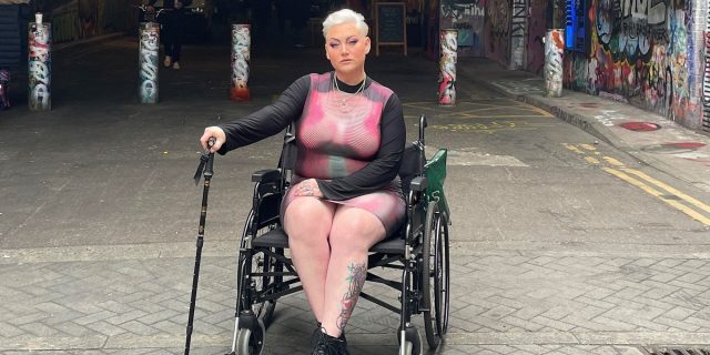 Contributor posing proudly in her wheelchair holding her cane