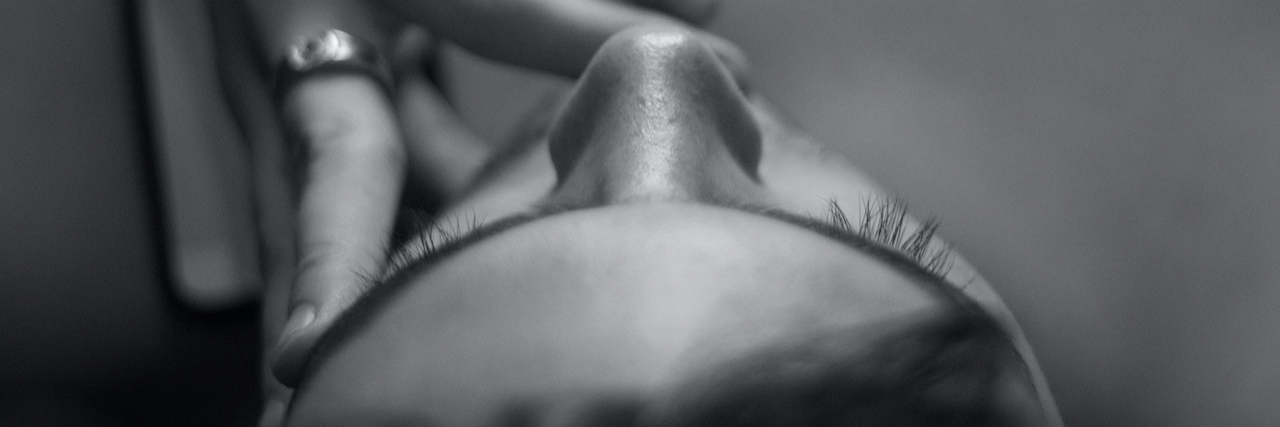 ADHD and the Relentless Search for Dopamine Black and white image from above of woman's head with fingers at her temple