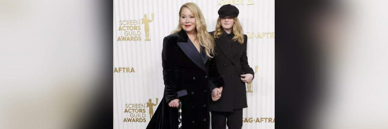 Christina Applegate stands proudly posing on the red carpet with her cane and next to her daughter