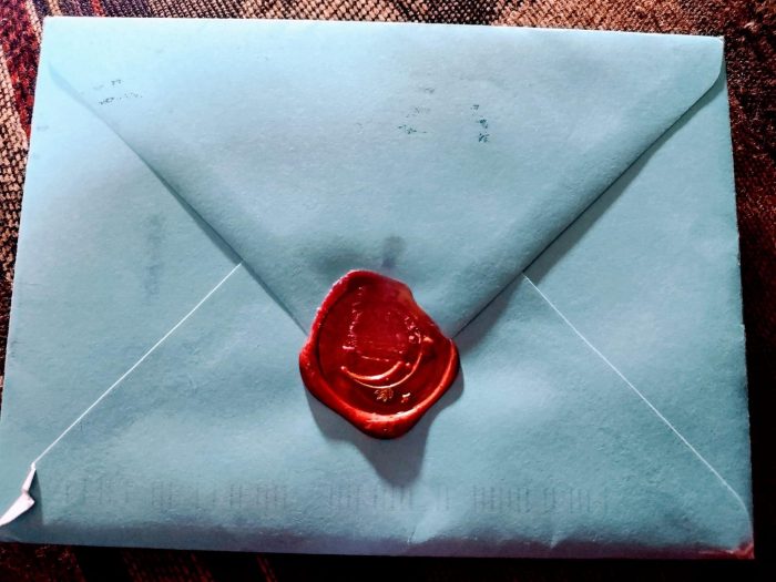 Back of blue envelope closed with a wax seal