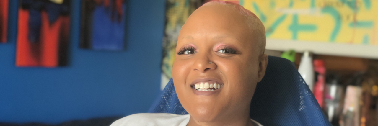 Contributor, a Black woman without hair, smiling