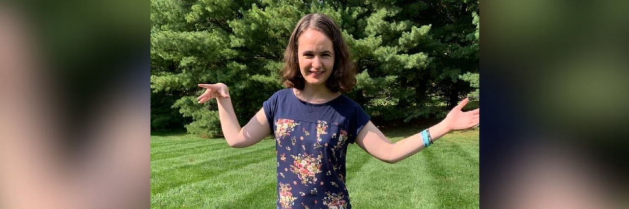 What It's Like Living 'in Between' With Disability  Contributor standing outside with her arms held out