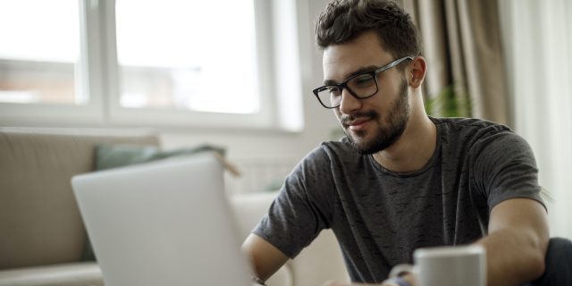 Man with glasses and beard on laptop
