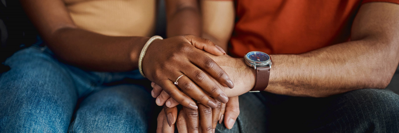 How Parkinson’s Affects Perception—and What Patients and Caregivers Can Do About It Cropped shot of an unrecognisable couple sitting together on the sofa at home and holding hands