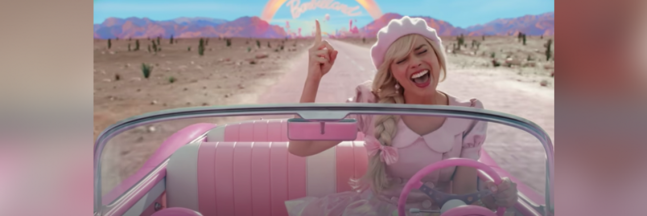 Image from "Barbie" movie of Barbie singing and driving away from Barbieland in pink convertible