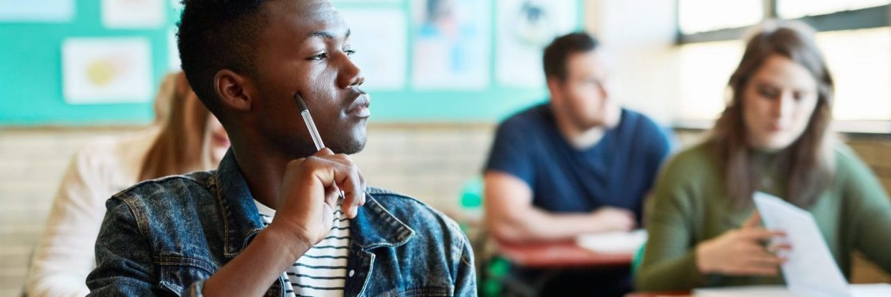 Unpacking How College Policies Impact Disabled Students Shot of a young man looking thoughtful at his desk in a classroom at university