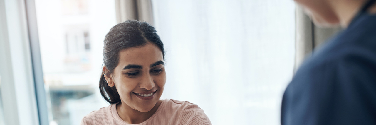 Everything You Need to Know for Your Rheumatology Appointment Woman of color in doctor's office having blood pressure taken