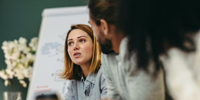 Nonprofit Doesn’t Mean No Profit, but My Paycheck Begs to Differ Woman professional in office having discussion with colleagues