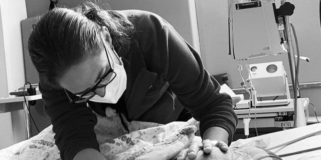 The System Is Breaking Us All: A Physician's Call to Action Contributor in her role as physician, carefully leaning over a patient