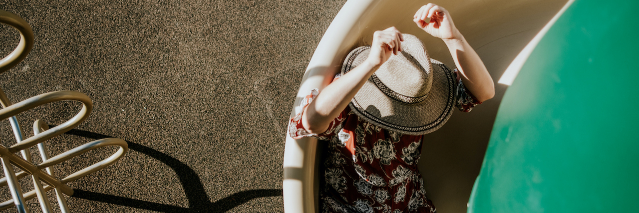 The Power of Radical Acceptance in Managing Fibromyalgia overhead view of a woman sliding down a spiral slide