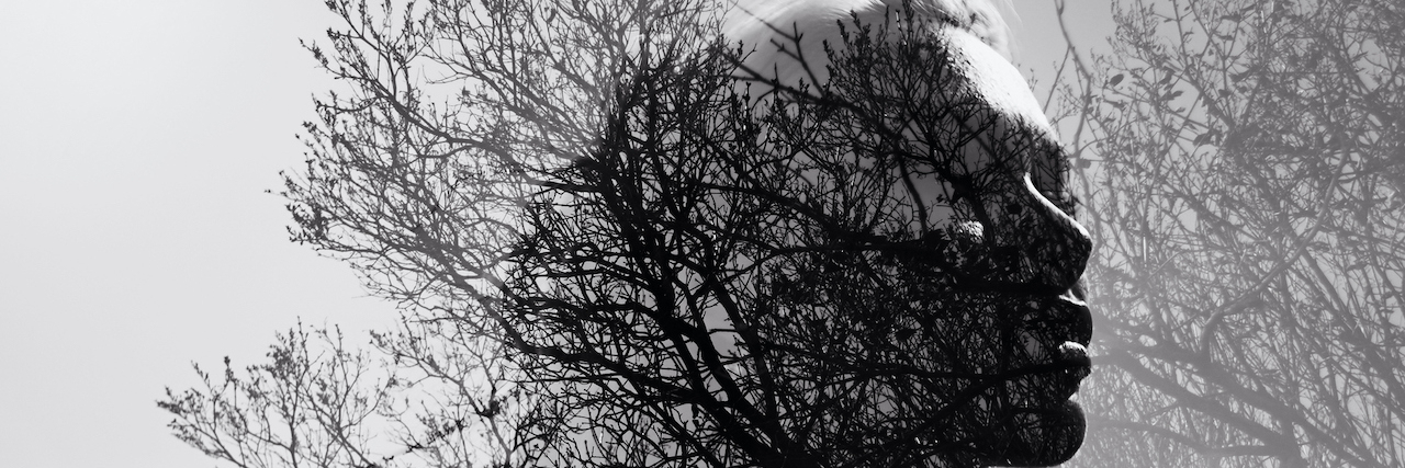 Why Chronic Pain Treatment Is Suicide Prevention Black and white portrait of a woman in double exposure with a background of bare trees and branches