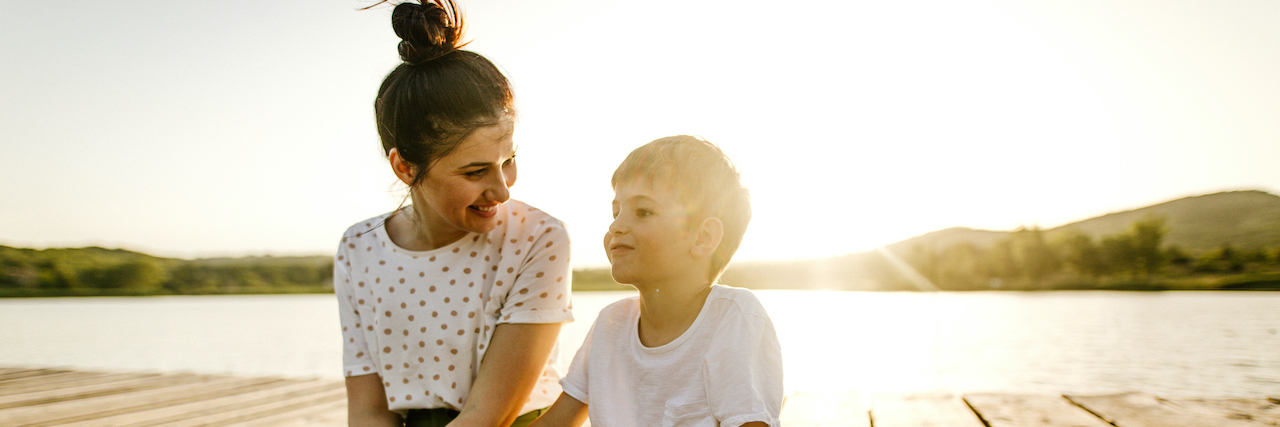 Leading With Empathy: Discipline Strategies for a Child With ADHD Boy and his mom, sitting on dock by a lake