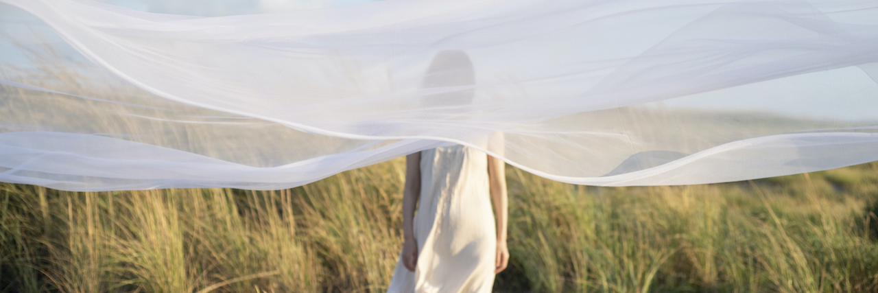 Are You Born With ADHD or Does It Develop Over Time? Woman standing behind translucent veil in nature