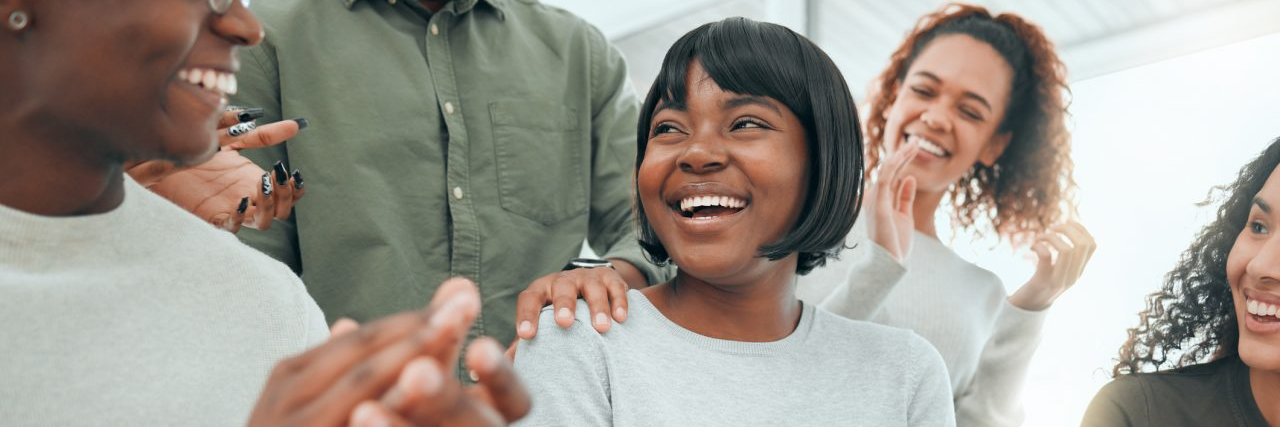 What Is Sobriety? Shot of an attractive young woman sitting while her support group celebrate her success