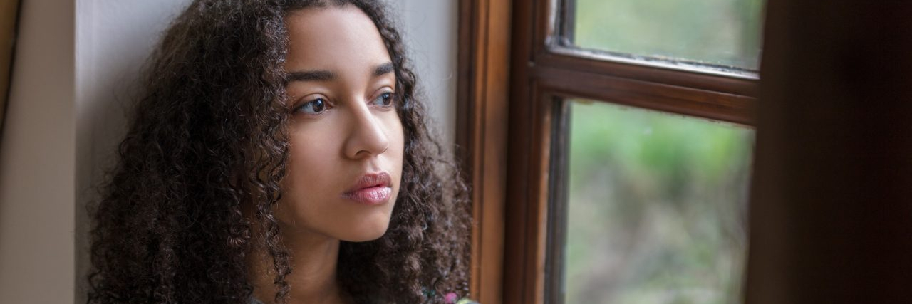 How and Why to Screen Yourself for Depression Beautiful mixed race teenager depressed or thoughtful looking out of a window
