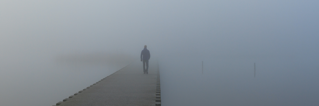 What Is ADHD Paralysis? Understanding Its Causes and Impact Person on jetty walking into dense fog