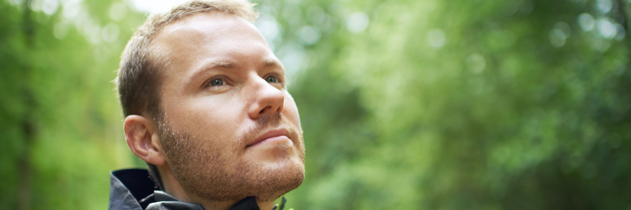 Unpacking Emotional Dysregulation in ADHD Man looking at the green leaves and trees around him