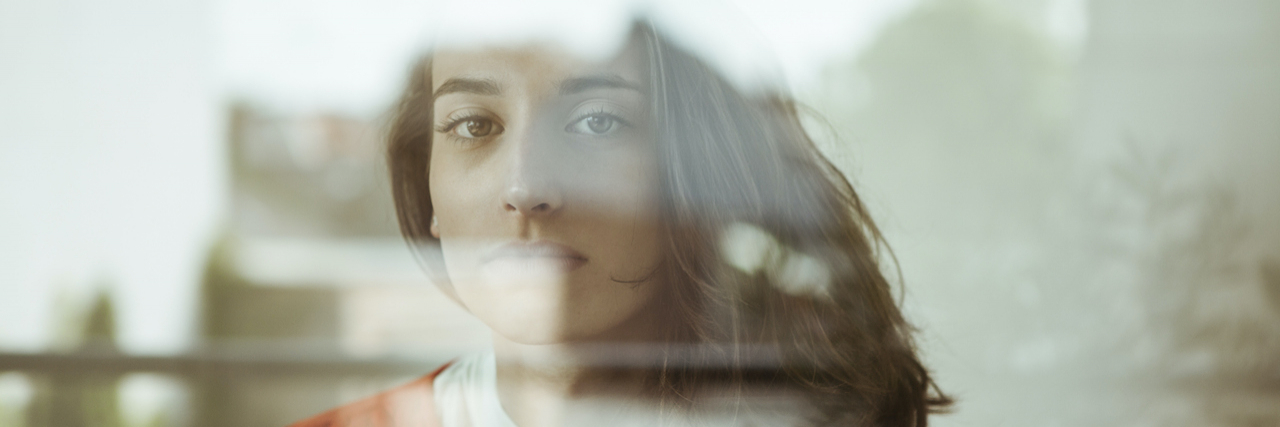 22 Myths Around Addiction And Substance Use Disorder Portrait of a woman with serious expression behind glass pane