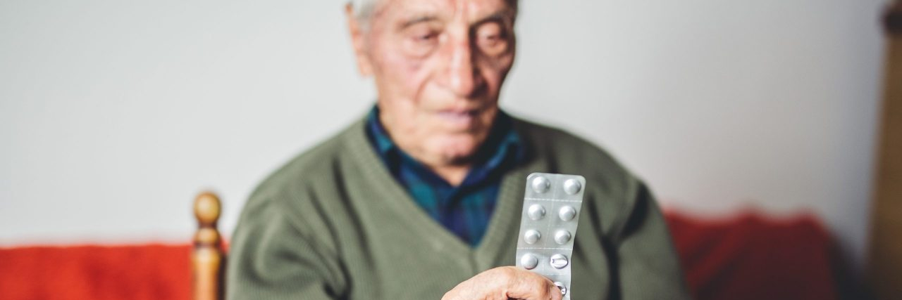 An old man in his 80s with his prescription drugs